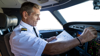 mature pilot in cockpit of private jet
